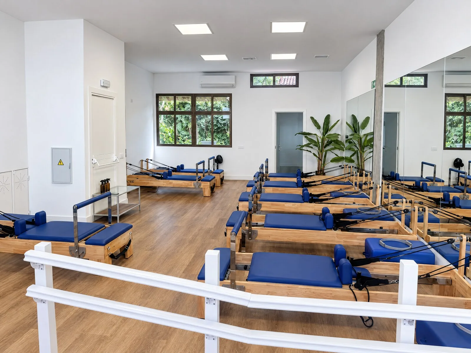 Sala de pilates reformer de Lagar Studio en Aravaca, con los reformers junto al ventanal al jardín