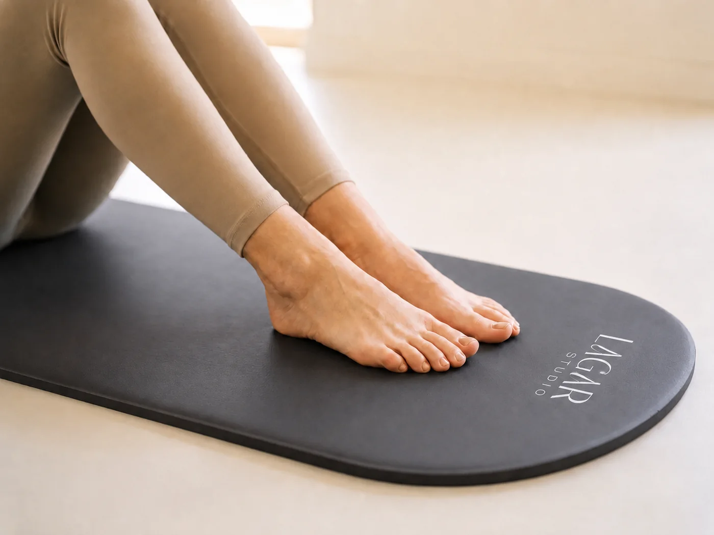 Pies descalzos sobre la colchoneta de Lagar Studio durante una clase de pilates suelo